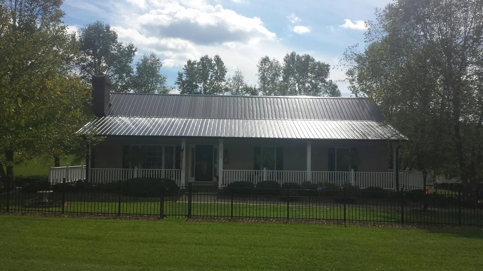 Gray metal roof on a brick ranch with a full width front porch — Gutter Guard Installation work by our crew in Oak Park